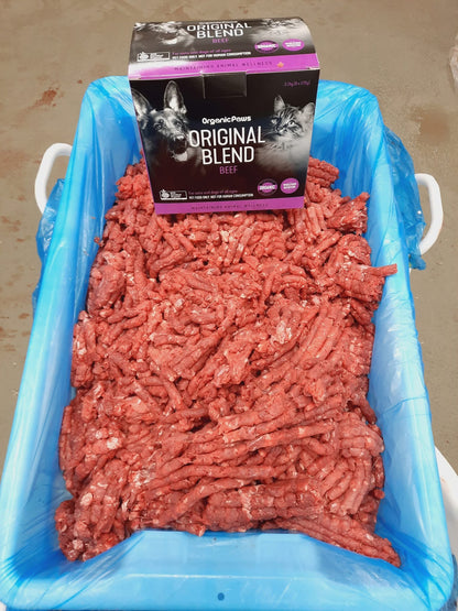Ground meat in a blue container with a package of Original Blend cat food on top.