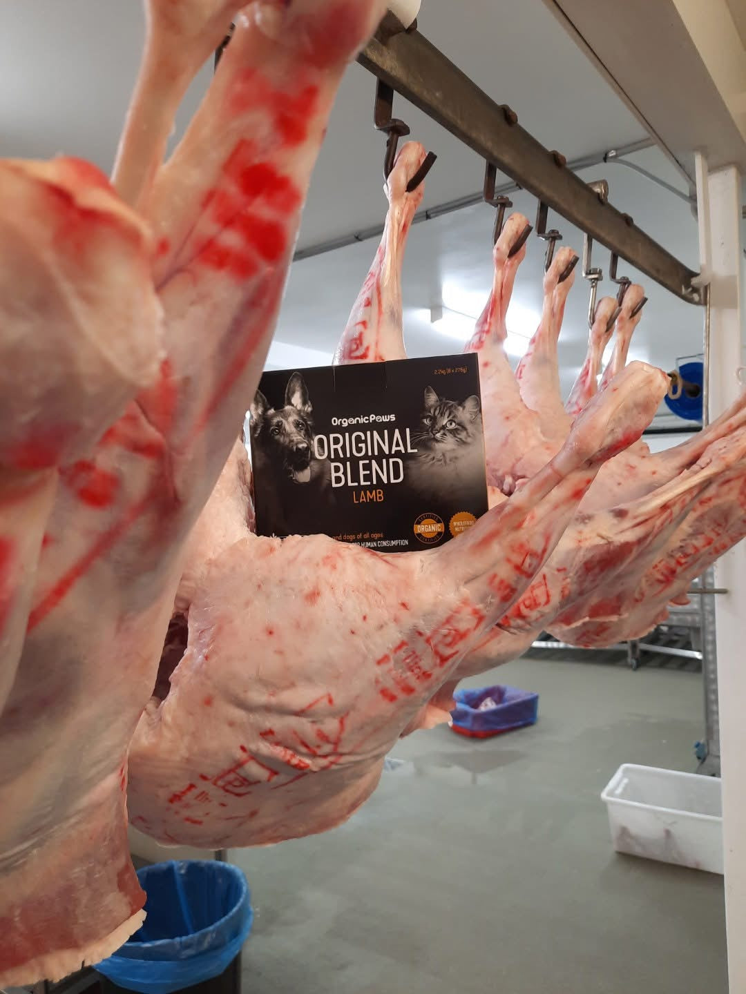 Hanging raw meat with a 'Original Blend' product in the foreground