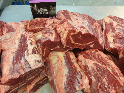 Raw beef on a cutting board with a container labeled 'Original Blend' in the background.