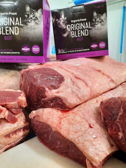 Raw meat with 'Original Blend' pet food boxes in the background