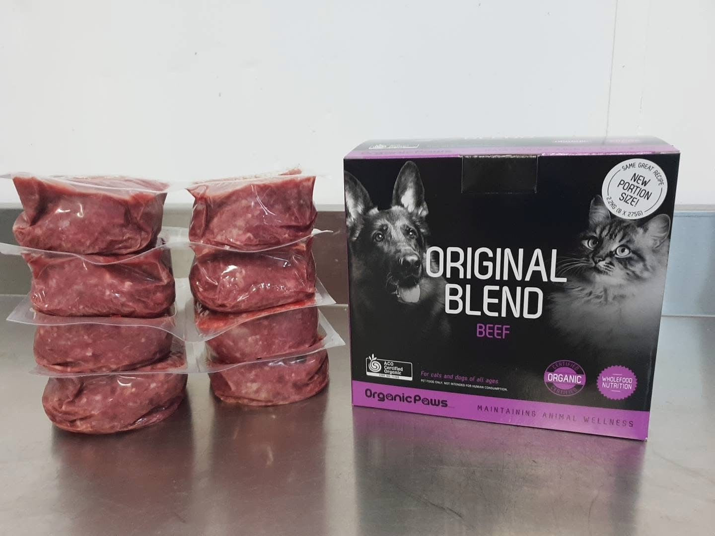 Raw meat packages and a box of 'Original Blend Beef' on a metallic surface.