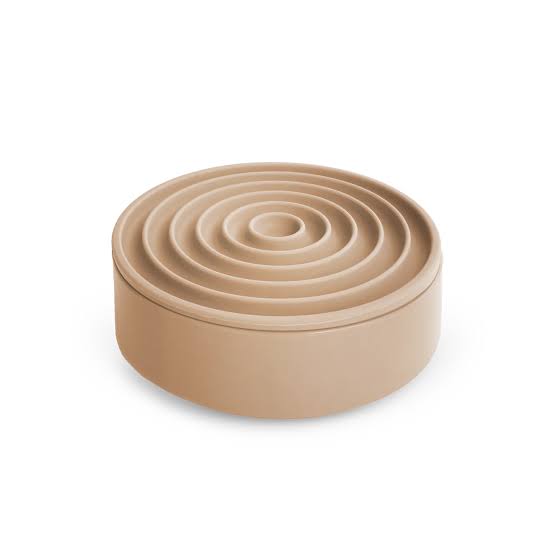 Beige circular container with concentric rings on a white background